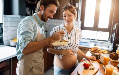 Portrait of happy couple cooking together in the kitchen at home
